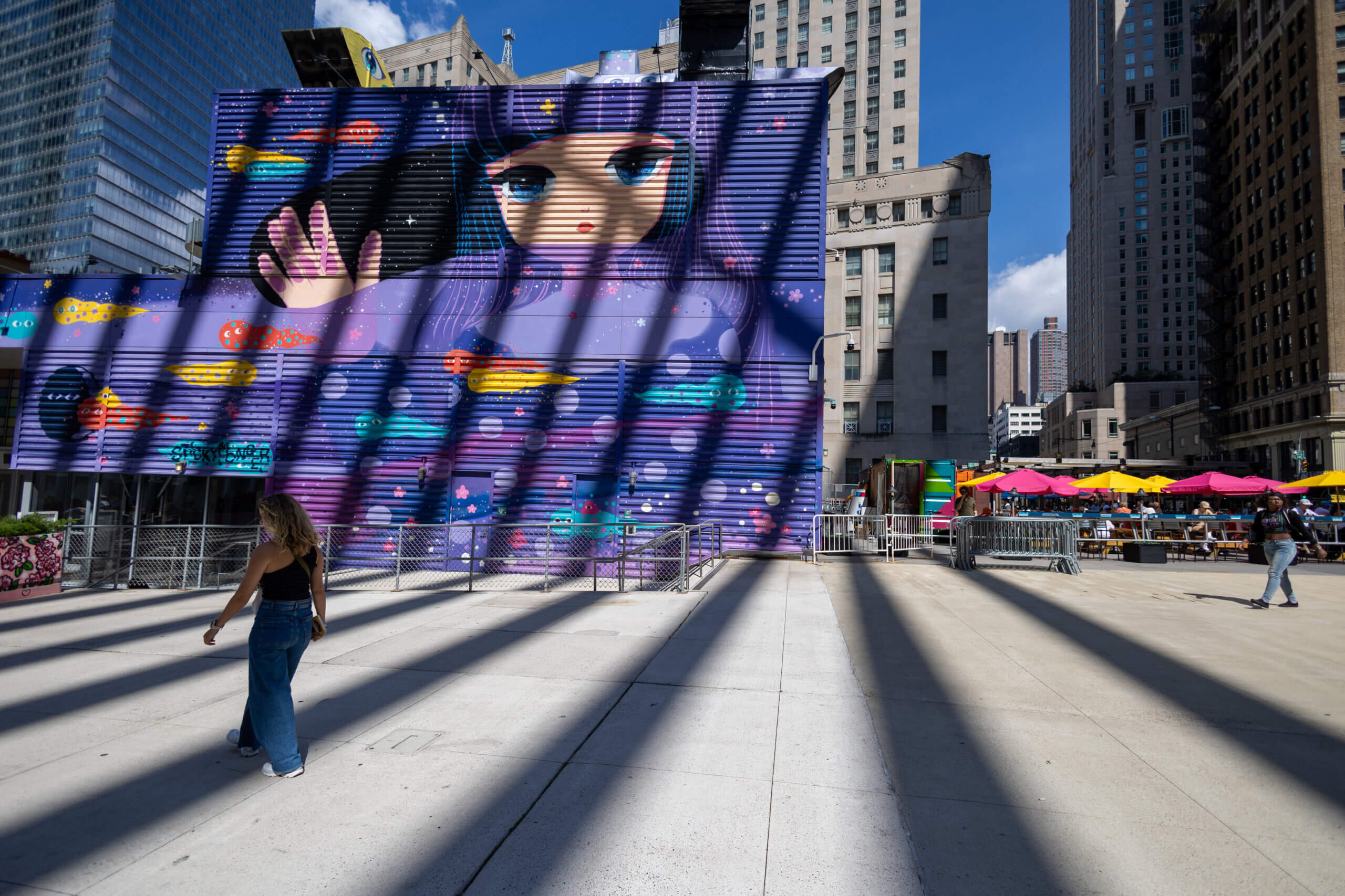 A photo capturing the shadows of the Oculus cast over the vibrant street art in the Ground Zero district, showcasing the blend of modern architecture and urban culture