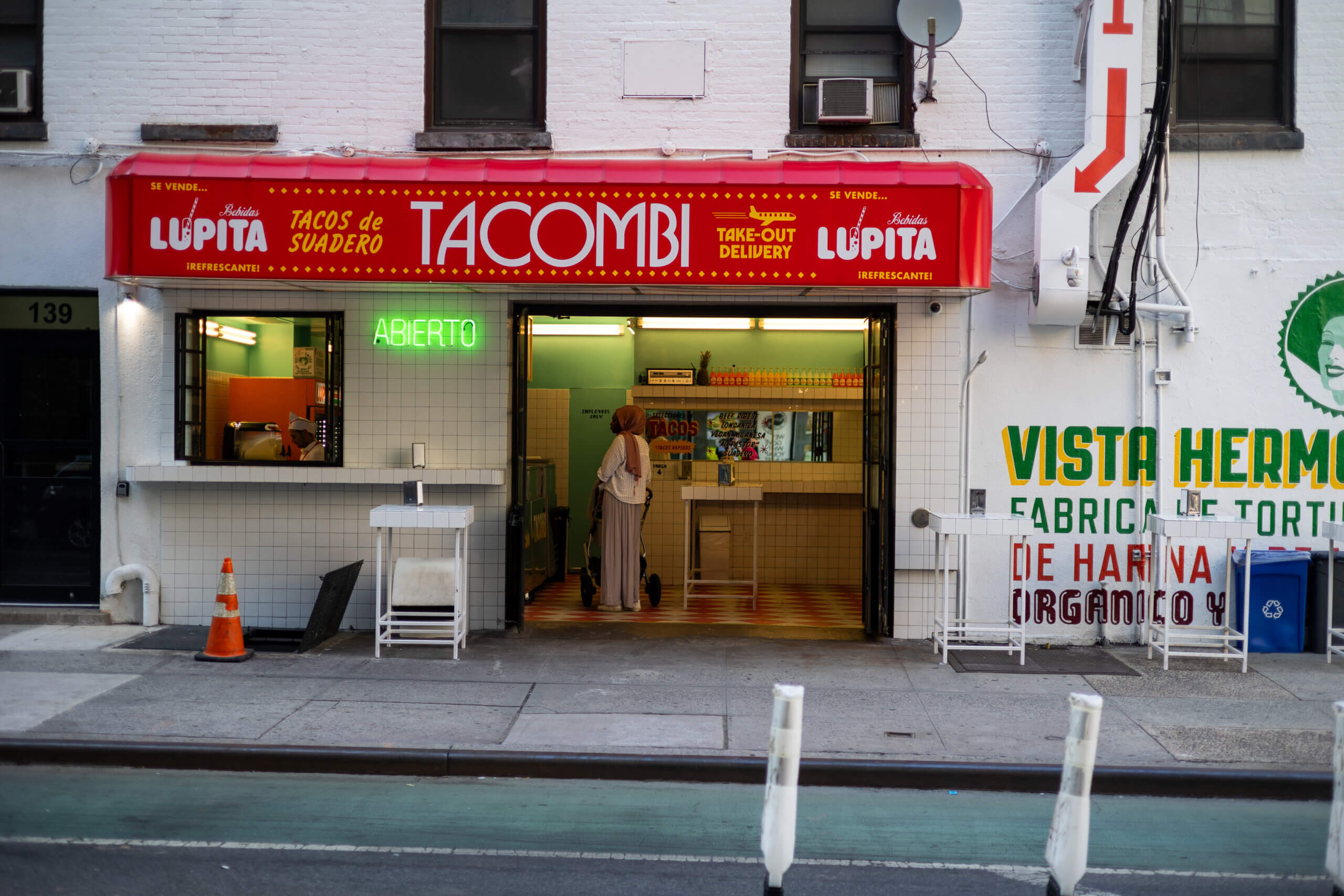 A photo of Tacombi restaurant in New York, featuring a customer seated and waiting to be served, capturing the vibrant atmosphere of the popular dining spot.