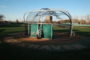 A photo of the baseball cage at Brookhaven College in Dallas, Texas, captured at sunset with warm tones highlighting the structure.