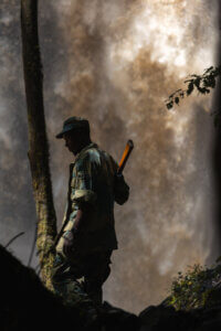 A photo of a guide standing in front of a waterfall at Chebera Churchura National Park in Ethiopia, a park renowned for its elephant population