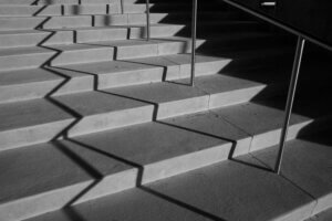 A black-and-white photo of a staircase at sunset, featuring dramatic graphic lines created by the shadows In Dallas