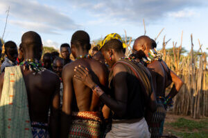 A photo of Hamar men in Ethiopia gathering and preparing moments before the bull-jumping ceremony begins.