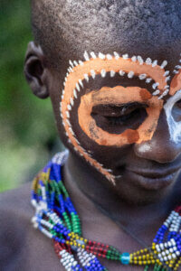 A photo from Ethiopia's bull-jumping ceremony, featuring the face of the jumper's friend adorned with traditional white paint decorations
