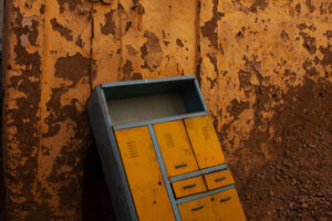 A vibrant yellow piece of furniture stands out against a textured brown wall in the city of Aswan, Egypt